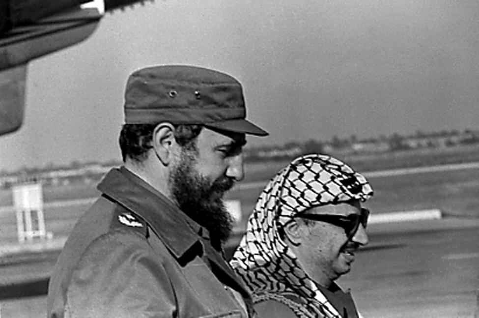 Fidel Castro (L) and PLO leader Yasser Arafat stand together at the airport in Havana during Arafat