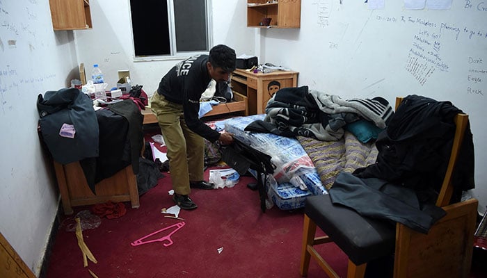 A Pakistani policeman inspect a room of a student Mashal Khan, who was killed by classmates, at a hostel at Abdul Wali Khan university in Mardan