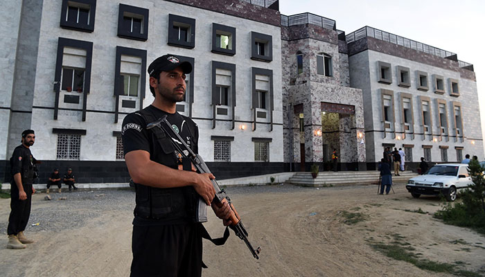 Pakistani policemen stand guard outside the hostel at Abdul Wali Khan university where students beat to death a classmate in Mardan — AFP