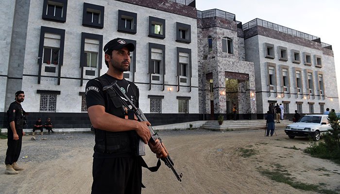 Policemen stand guard outside the hostel at Abdul Wali Khan university where students beat to death a classmate in Mardan/AFP.