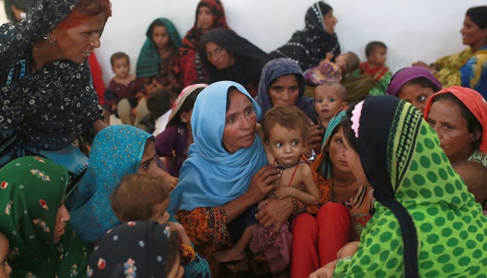 In this photograph taken on September 7, 2016, Mah Pari (C) carries her son Gul Mir, as she waits for her turn at the mobile feeding centre 