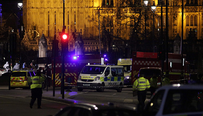 British police officers stand on duty as forensics officers work outside the Carriage Gates entrance