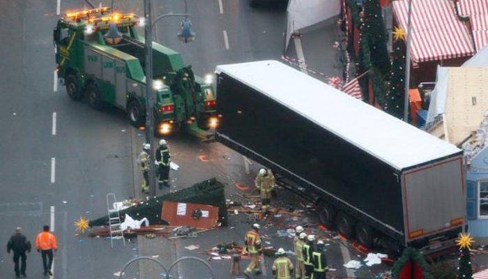 Rescue workers tow the truck which ploughed into a crowded Christmas market in Berlin - Reuters