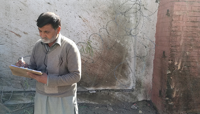 An investigator takes notes at a courthouse after an attack by suicide bombers in Charsadda - Reuters