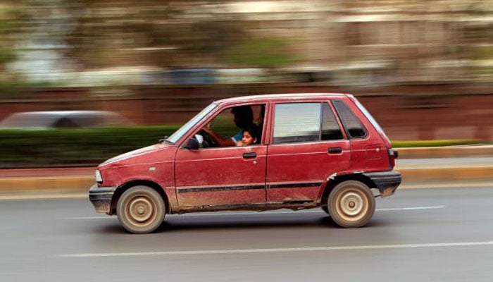 A girl looks out from a car as she travel along a road in Rawalpindi.—Reuters photo