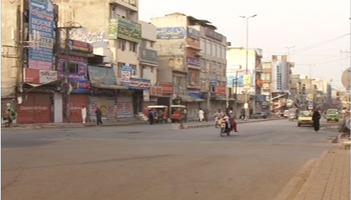A motorcycle zooms past an empty street in Rawalpindi after containers have been removed