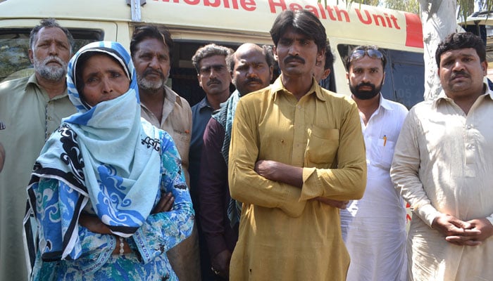 Bereaved relatives wait at a hospital to receive the bodies of victims murdered at the shrine. PHOTO: AFP 