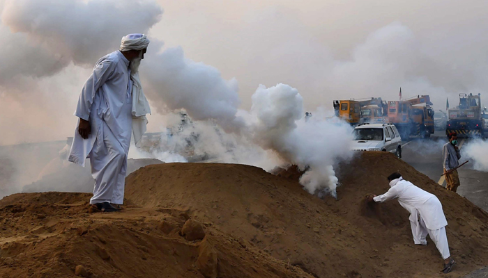 PTI supporters dump tear gas shell during clashes with police as they matched towards the capital- Photo AFP 