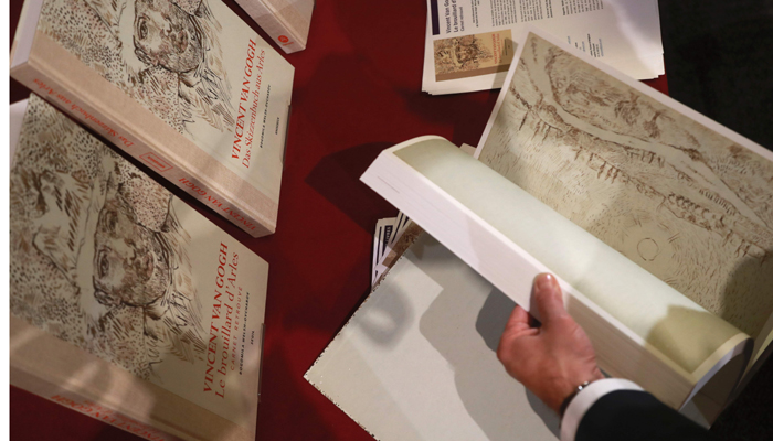 A man leafs through the pages of a book of drawings from Dutch post-impressionist painter Vincent Van Gogh at the architecture academy in Paris on November 15, 2016 - AFP
