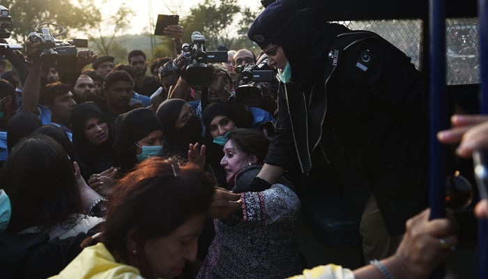Policewomen arrest an activist of PTI near the house of PTI chief Imran Khan in Islamabad-Photo AFP