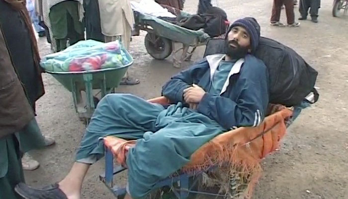 A traveler rests at a wheel barrow after the Pak-Afghan border closes for traffic- Geo News