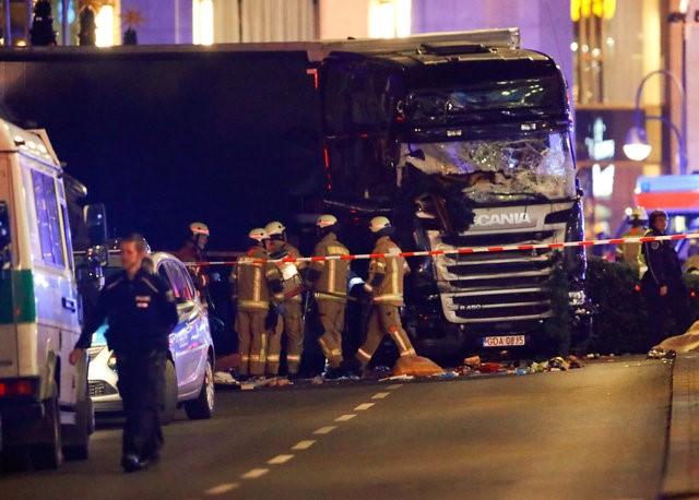  Police and emergency workers stand next to a crashed truck at the site of an accident at a Christmas market on Breitscheidplatz square near the fashionable Kurfuerstendamm avenue in the west of Berlin, Germany, December 19, 2016. REUTERS/Fabrizio Bensch