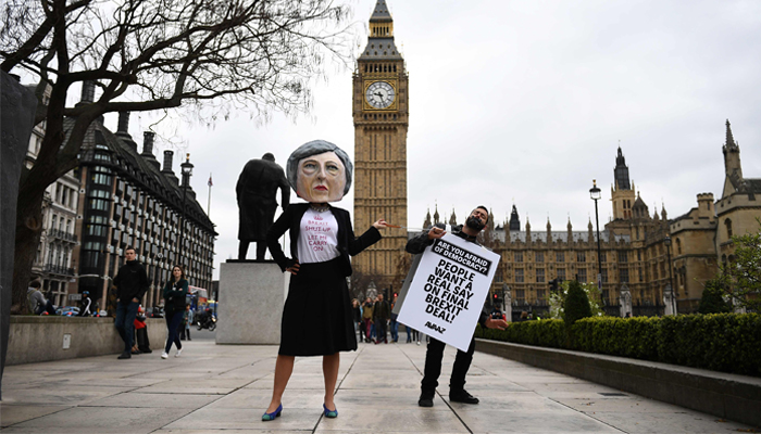 null A demonstrator wearing a mask depicting Britain´s Prime Minister Theresa May, protests against the United Kingdom´s triggering of Article 50, outside the Houses of Parliament in central London on March 29, 2017. British Prime Minister Theresa May will formally launch Brexit today after signing the letter to begin the country´s departure from the European Union. / AFP / Justin TALLIS