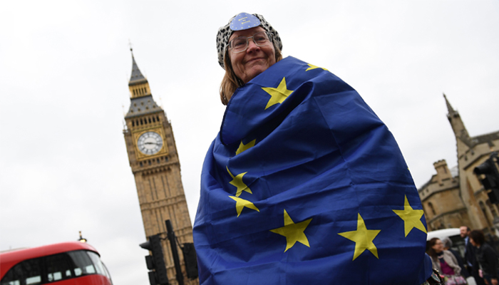null A pro-European Union (EU) supporter stands draped in an EU flag near the Houses of Parliement in central London on March 29, 2017. British Prime Minister Theresa May will formally launch Brexit today after signing the letter to begin the country´s departure from the European Union. / AFP / Justin TALLIS
