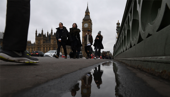 null Commuters walks over Westminster bridge by the Houses of Parliament in central London on March 29, 2017. British Prime Minister Theresa May will formally launch Brexit today after signing the letter to begin the country´s departure from the European Union. / AFP / Justin TALLIS