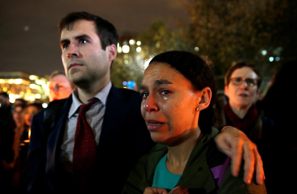 A woman cries while taking part in an anti-Trump candlelight vigil in front of the White House in Washington. 