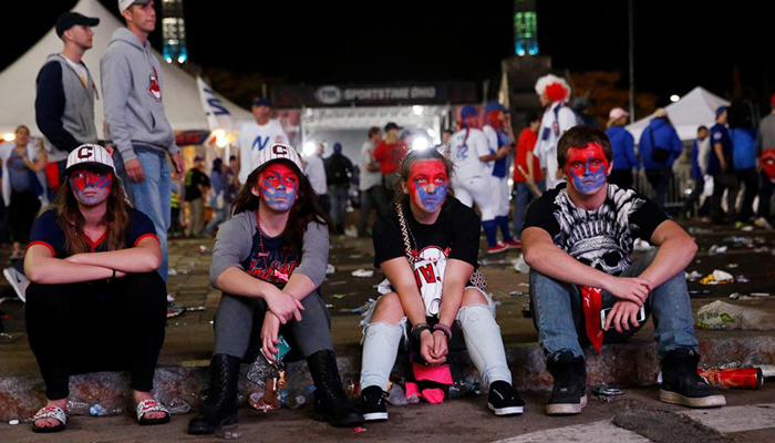 Fans of the Cleveland Indians sit dejected after the loss outside Progressive Field.