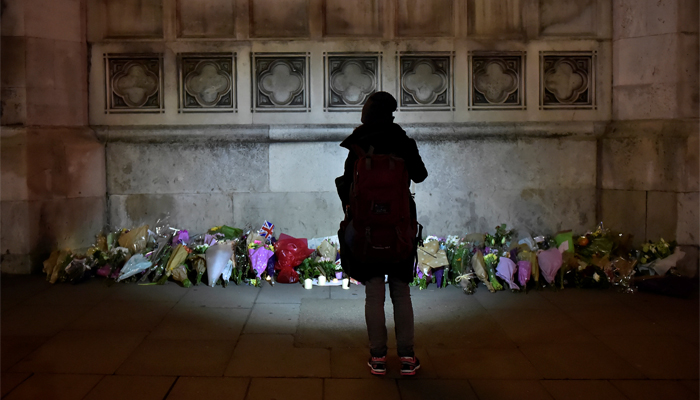 A woman looks at floral tributes laid in Westminster the day after a attack in London, Britain, March 23, 2017. REUTERS/Hannah McKay