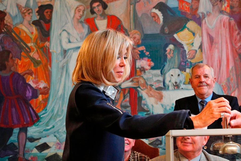 Brigitte Trogneux the wife of French presidential   election candidate for the En Marche ! movement   Emmanuel Macron casts her ballot at a polling   station in Le Touquet, northern France, on May 7,   2017, during the second round of the French   presidential election. / AFP / POOL / Christophe   Ena