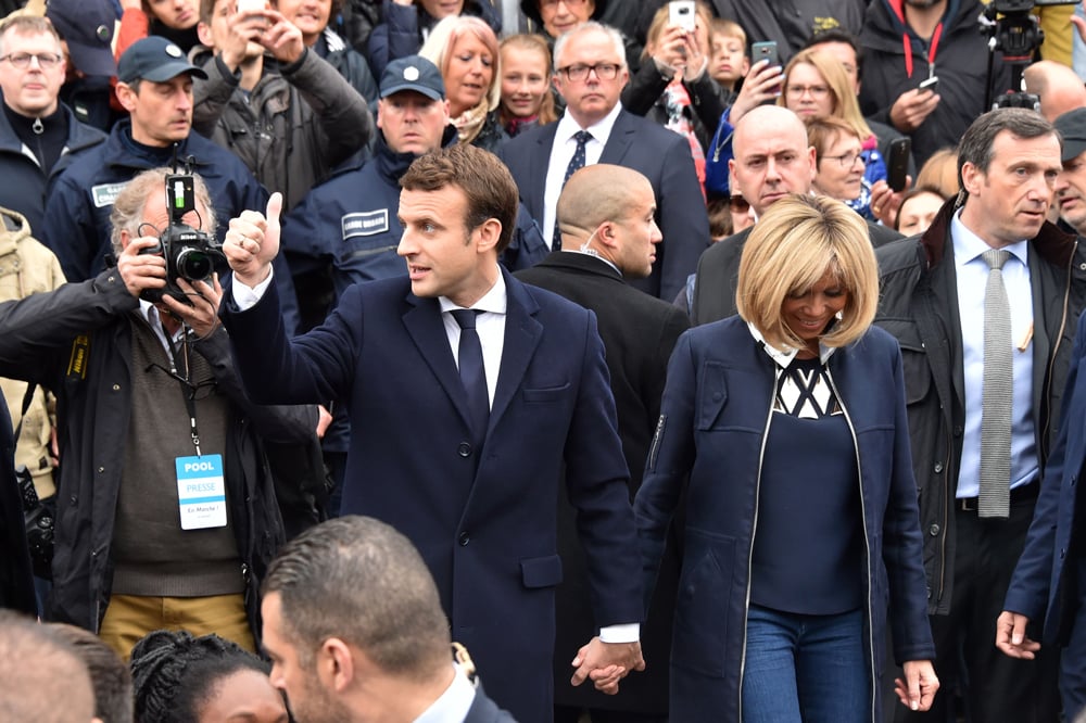 French presidential election candidate for the En   Marche ! movement Emmanuel Macron (L) give a   thumbs up as he and his wife Brigitte Trogneux   leave after voting in Le Touquet, northern   France, on May 7, 2017, during the second round   of the French presidential election. / AFP /   Philippe HUGUEN