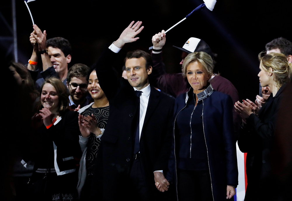 French president-elect Emmanuel Macron (C) and   his wife Brigitte Trogneux (C-R) wave to the   crowd in front of the Pyramid at the Louvre   Museum in Paris on May 7, 2017, after the second   round of the French presidential election. AFP /   Patrick KOVARIK