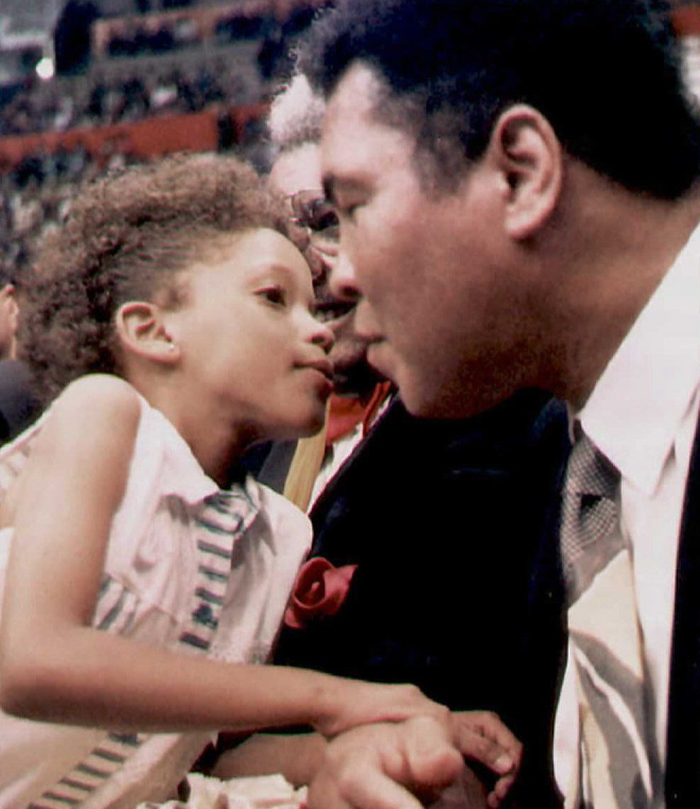 This photo taken on December 16, 1994 shows Muhammad Ali is kissed by a young Ecuadoran girl at the Quito´s Ruminahui Coliseum, Ecuador- AFP 