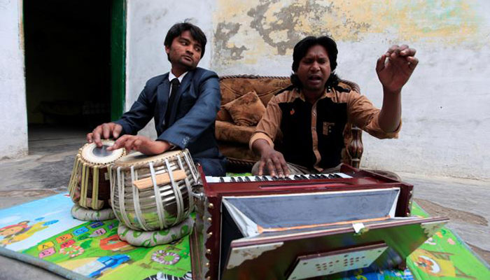 null Nazar Gill, (R) a local singer, practices a song along with his brother at his residence in Rawalpindi- REUTERS