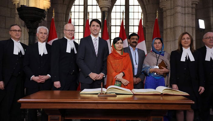 Malala Yousafzai and Canadian Prime Minister Justin Trudeau pose for pictures after Malala signed a guest book in Ottawa, Ontario, April 12, 2017/AFP