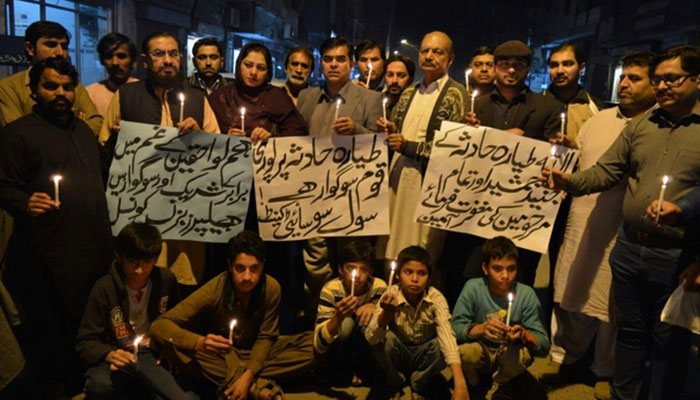 Pakistani people hold candles in memory of victims of plane crash in Multan on December 7, 2016- AFP