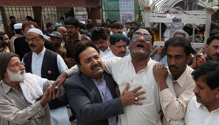 Men comfort each other as they attend the funeral of a relative who was killed in a suicide blast at the tomb of Sufi saint Syed Usman Marwandi, also known as the Lal Shahbaz Qalandar shrine. February 17, 2017. REUTERS/Akhtar Soomro
