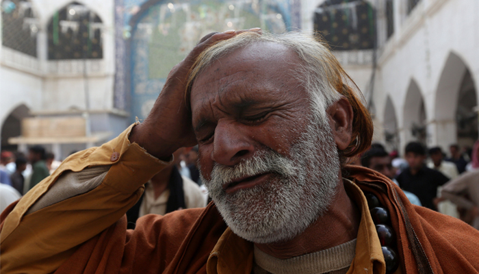 A man beats his head as he mourns the death of a relative who was killed in a suicide blast. February 17, 2017. REUTERS/Akhtar Soomro 