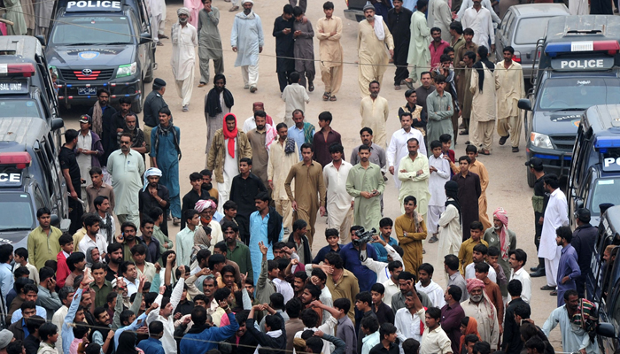 Pakistani devotees shout slogans against the bomb attack on the shrine of 13th century Muslim Sufi saint Lal Shahbaz Qalandar. AFP / ASIF HASSAN