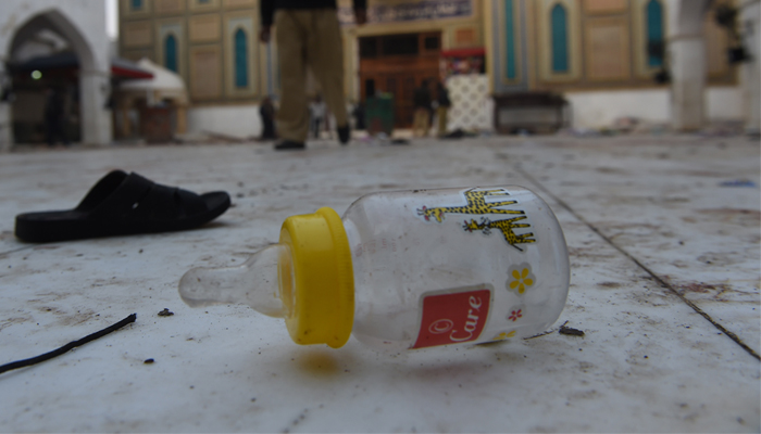 Slippers and a baby feeder of blast victims lie on the ground at the 13th century Muslim Sufi shrine. AFP / ASIF HASSAN