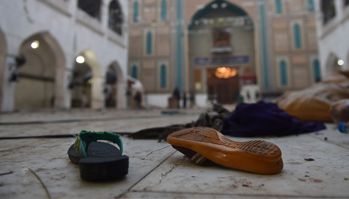 Slippers of blast victims lie on the ground at the 13th century Muslim Sufi shrine of Lal Shahbaz Qalandar. AFP / ASIF HASSAN