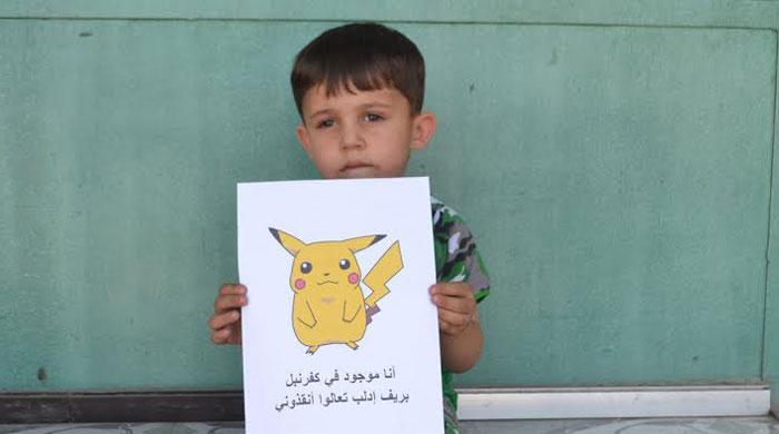 Syrian children hold Pokémon photos urging people to find and save them