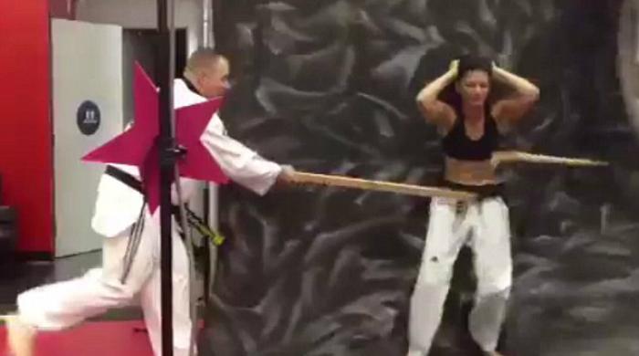 A tough karate girl breaks a stick using only her abs