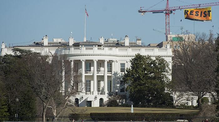 Greenpeace unfurls anti-Trump banner on crane near White House