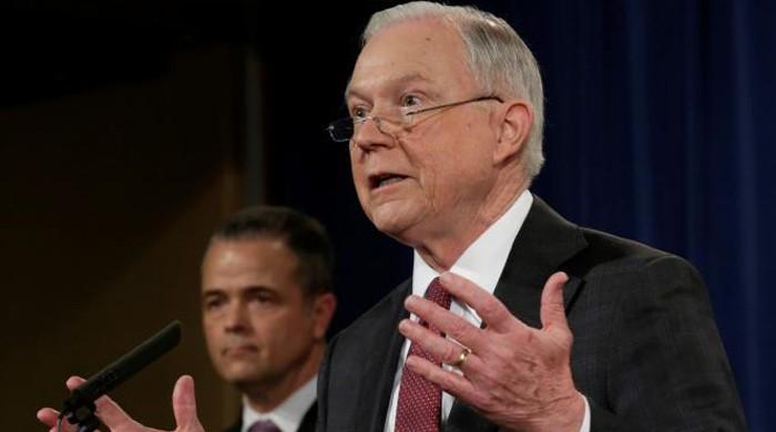 Under fire, Trump's attorney general removes himself from campaign probes