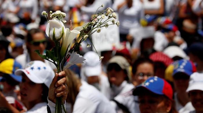 Roses in hand, Venezuelan women protesters face security forces