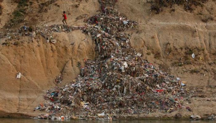A boy runs past a pile of garbage along the river Ganges in Mirzapur, India, April 19, 2017. Photo: REUTERS/file