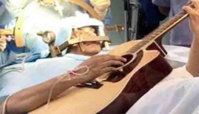 Indian musician plays guitar during brain surgery