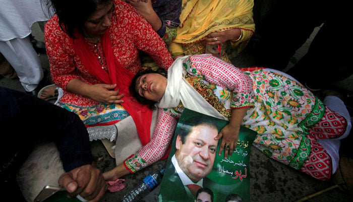 A supporter of Pakistan´s Prime Minister Nawaz Sharif passes out after the Supreme Court´s decision to disqualify Sharif in Lahore, Pakistan July 28, 2017/ Reuters