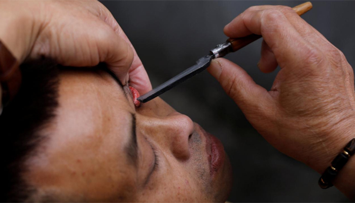 Flipping lids! Chinese barber offers eyelid shaves
