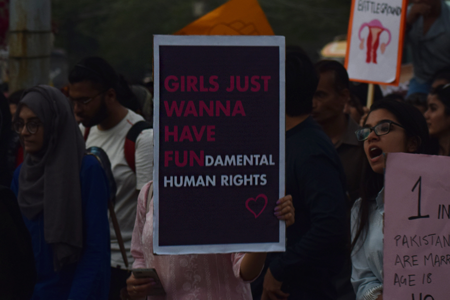 A girl carries a placard that reads 'Girls just wanna have fun-damental human rights' during the Aurat March 2018 held at Frere Hall, Karachi, Pakistan, March 8, 2018. Geo.tv/Author