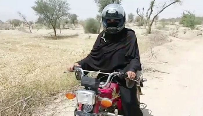 Helmet on burqa: Teacher rides motorbike for kilometres to reach school in DG Khan