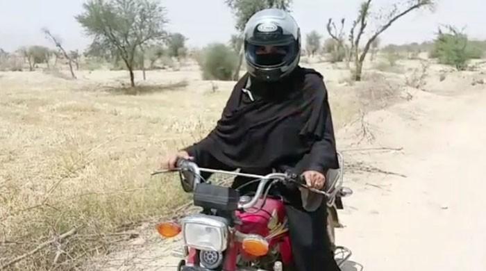 Helmet on burqa: Teacher rides motorbike for kilometres to reach school in DG Khan