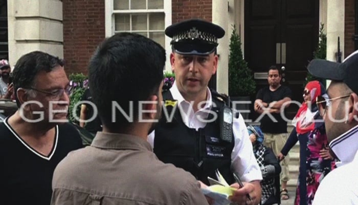 A Metropolitan Police officer speaks to a crowd that gathered after protesters try to break into the Sharifs' Avenfield flats in London, Britain, July 9, 2018. Geo.tv via Geo News/Screenshot