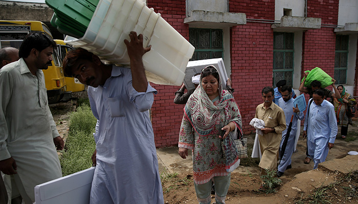 Election officials carry election materials at a distribution centre ahead of general election in Islamabad, Pakistan, July 24, 2018. Photo: Reuters