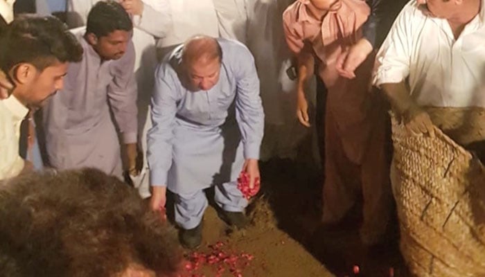 Nawaz Sharif laying rose petals on the grave of Kulsoom Nawaz