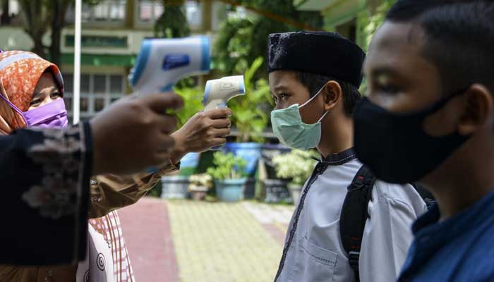 Indonesia posts record virus infections as experts slam brakes on easing restrictions